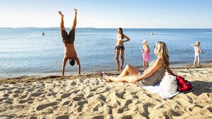 A beach scene with people relaxing and sunbathing. - Apartment in Rechin Right on the Water (Rechlin)