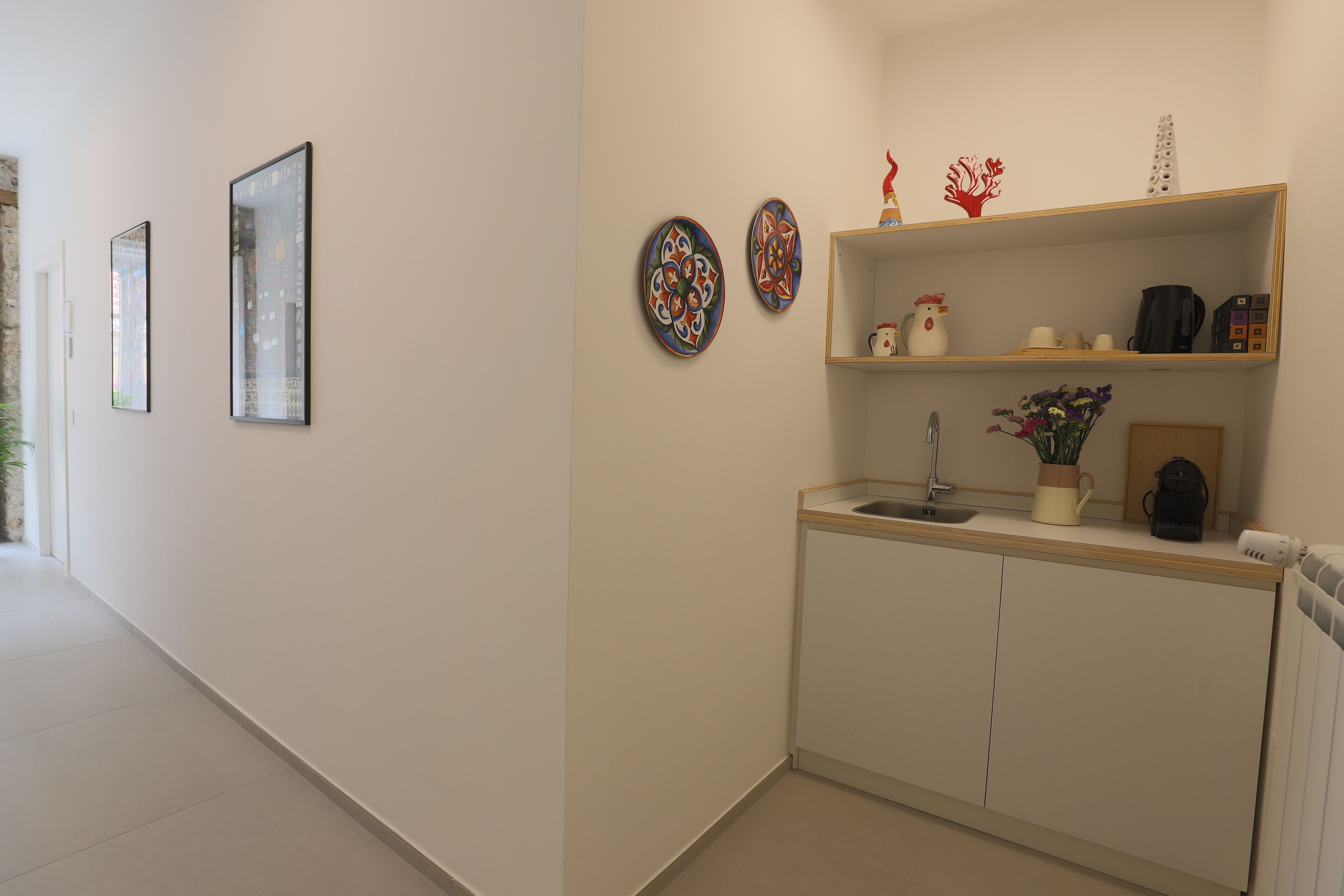 A modern kitchen with a sink, cabinets, and decorative plates.