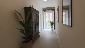 A hallway with a large potted plant, a wooden cabinet, and a framed picture on the wall. - DESIDERIO GUEST HOUSE (Salerno)