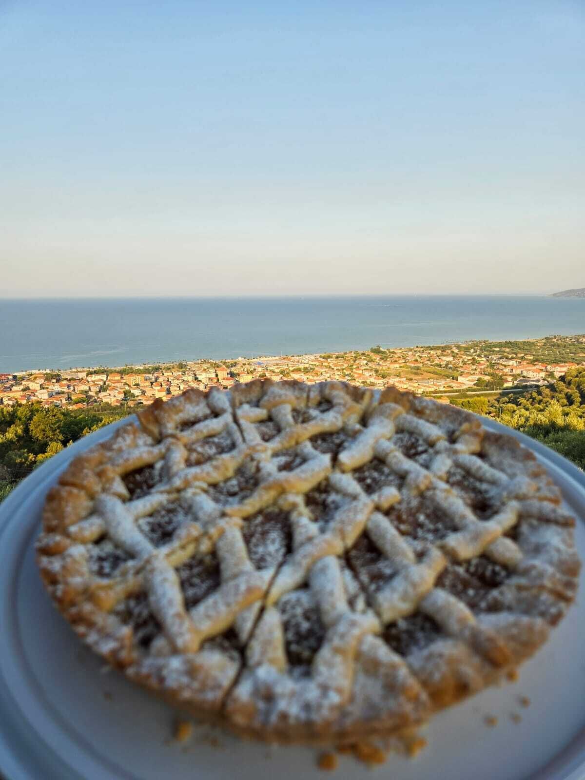 Un pastel en un plato con vistas al mar de fondo.
