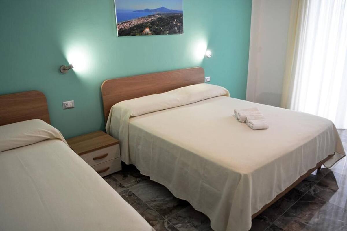 Ein Hotelzimmer mit zwei Betten, einem Nachttisch und einer Wandleuchte.