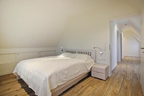 Ein Schlafzimmer mit einem Einzelbett, einem Nachttisch und einem Holzboden.