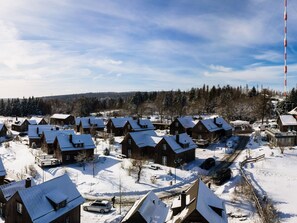 Un pueblo cubierto de nieve con casas de madera y cielo despejado.