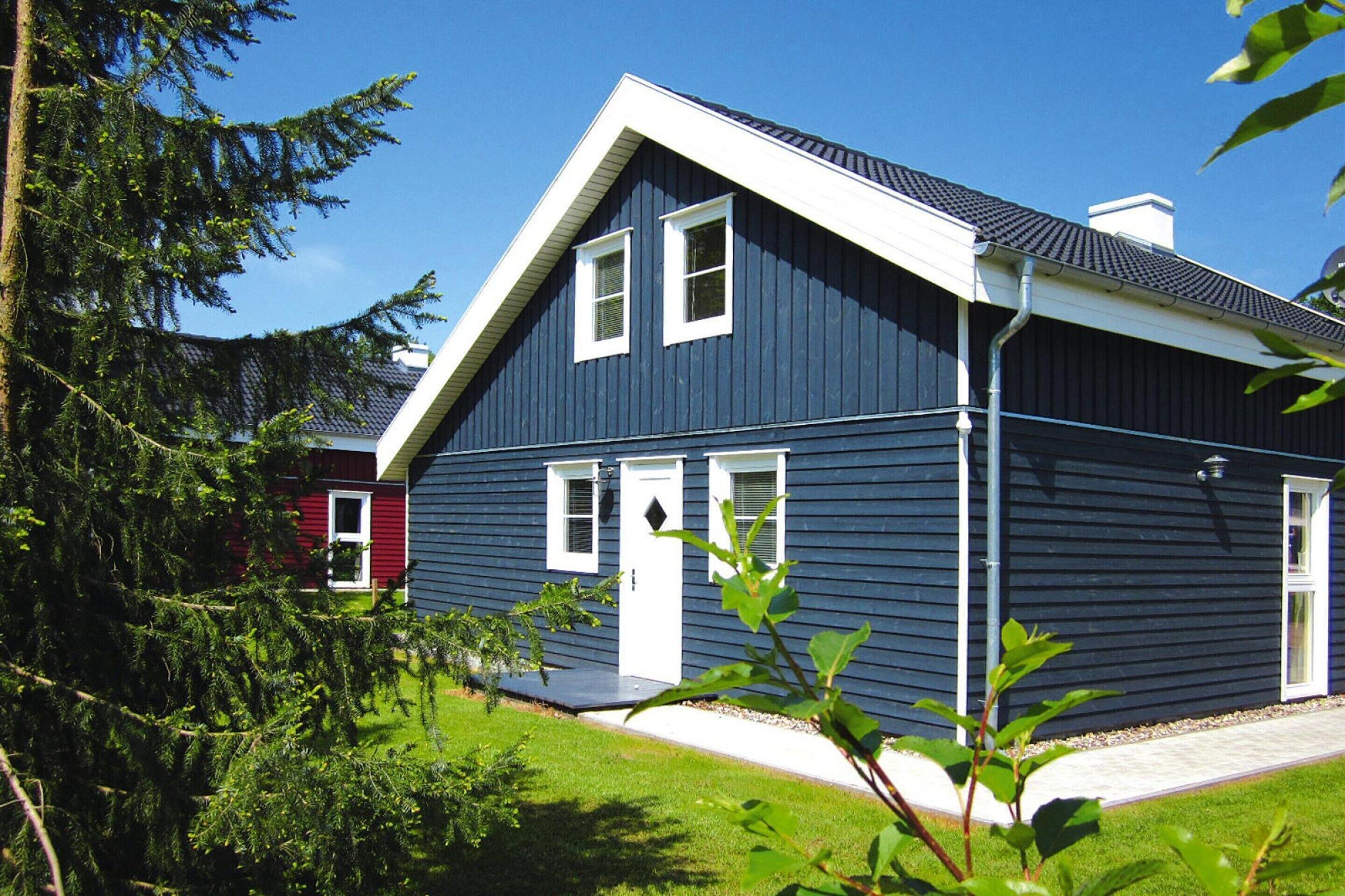 A two-story house with a dark blue exterior, white trim, and a sloped roof.