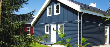 A two-story house with a dark blue exterior, white trim, and a sloped roof.