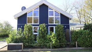 A two-story house with a gabled roof, large windows, and a satellite dish. - Ferienhaus Seeidyll am Dummer See, Dummer (Dümmer)