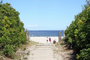 A wooden pathway leading to a sandy beach with dense foliage on either side. - Apartment, Dassow (Dassow)