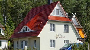 A two-story building with a red-tiled roof and a sign that reads "Hotel Nachtigall." - Ferienhaus Nachtigall, Glowe (Glowe)