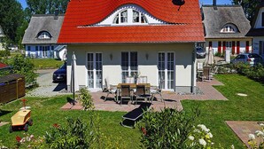 A house with a red roof, a satellite dish, and a patio with outdoor furniture.