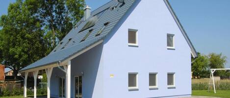 A modern house with a sloped roof, a covered porch, and a small front yard.