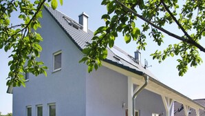 A modern two-story building with a flat roof, large windows, and a covered porch area. - Doppelhaushalfte in Seehausen am Oberuckersee (Oberuckersee)