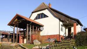A traditional house with a sloped roof, a wooden porch, and a brick foundation. - Holiday Home Inselperle, Putbus (Putbus)