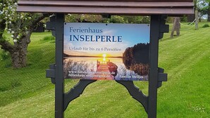 A sign for a family-friendly inn with a view of a sunset over a lake. - Holiday Home Inselperle, Putbus (Putbus)