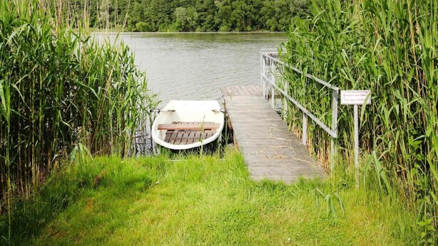 A boat docked at a wooden pier with a sign indicating a protected area. - Ferienwohnung Alte Schmiede, Zemitz (Zemitz)