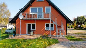 A two-story house with a balcony, a satellite dish, and a staircase leading to the upper floor. - Ferienwohnung Alte Schmiede, Zemitz (Zemitz)