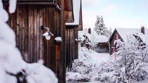 En träbyggnad med ett snötäckt tak och en synlig skorsten.