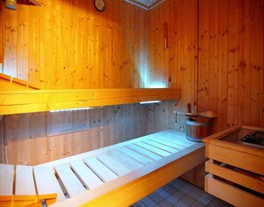 A sauna room with wooden walls, a bench, a bucket, and a wooden cabinet. - Ferienhaus, Zirchow (Zirchow)
