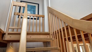 Eine Holztreppe mit Geländer, die zu einer oberen Etage führt.