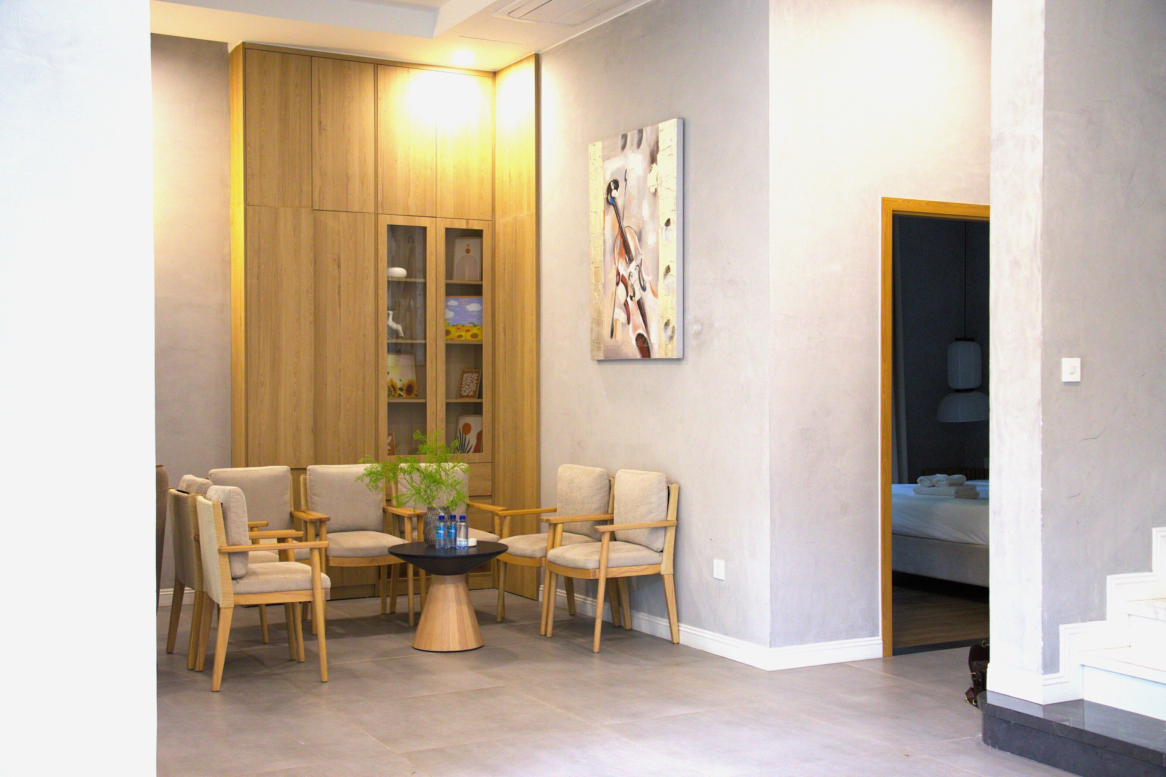 Un intérieur moderne avec un coin salon, des lambris en bois et un tableau au mur.