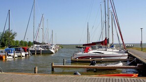 A marina with several sailboats docked at wooden piers. - Doppelhaushaelfte am Hafen von Neuendorf (Saal)