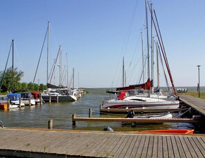 Un port de plaisance où plusieurs voiliers sont amarrés à des quais en bois.