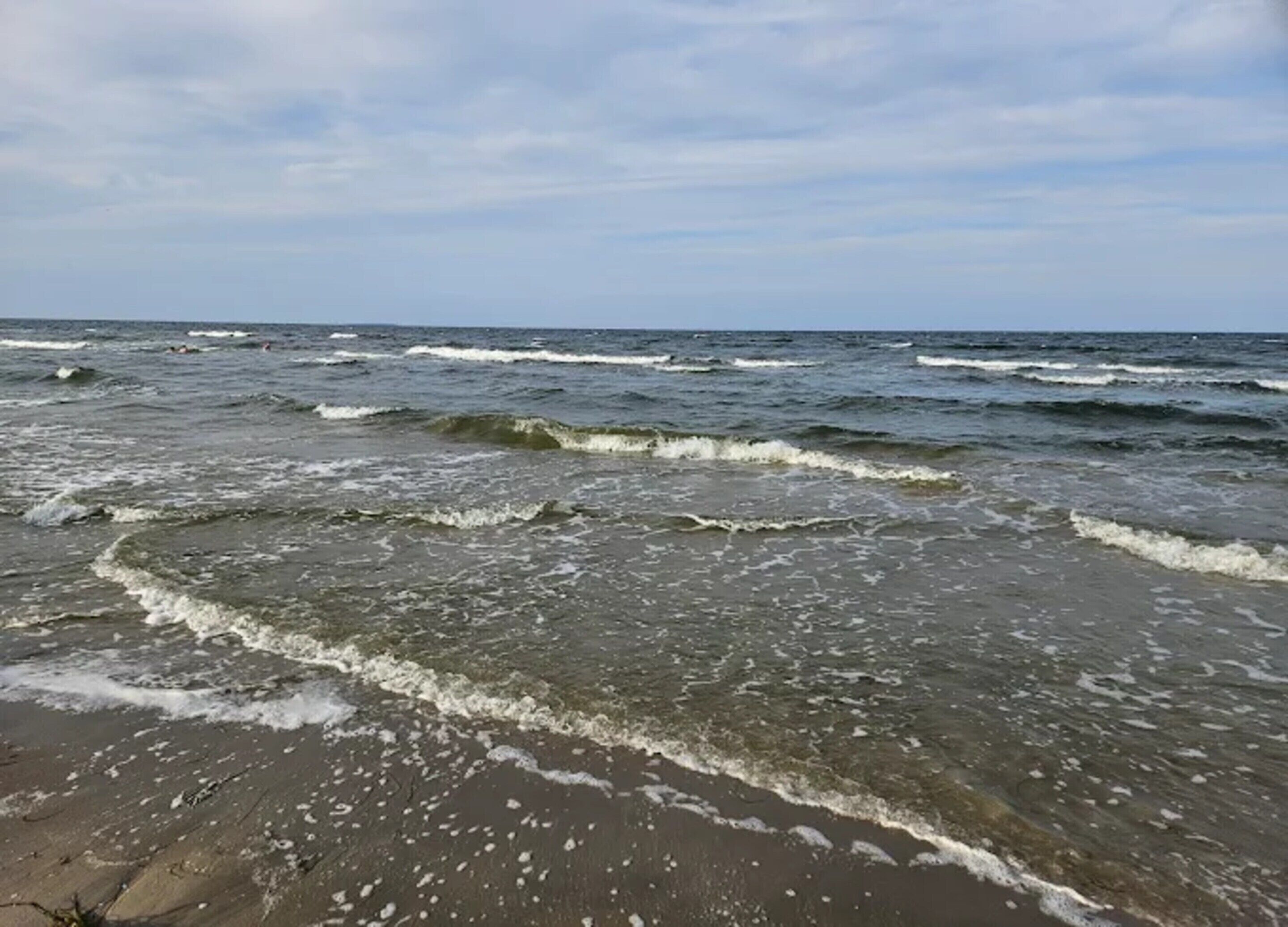 A beach with waves approaching the shore.