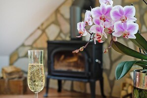 A glass of champagne, a potted orchid, and a stone fireplace in a room. - Apartment, Kenz-kustrow (Kenz-Küstrow)