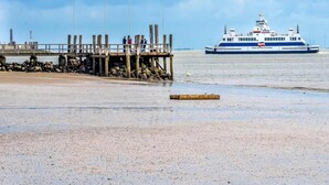 A pier with flags of the USA, Brazil, and Italy, and a ferry in the background. - Ferienwohnung in Oevenum auf Foehr (Oevenum)