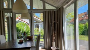 A dining area with a table, chairs, and a view of the outdoors. - Ferienhaus Muritzzeit in Robel an der Muritz (Röbel/Müritz)