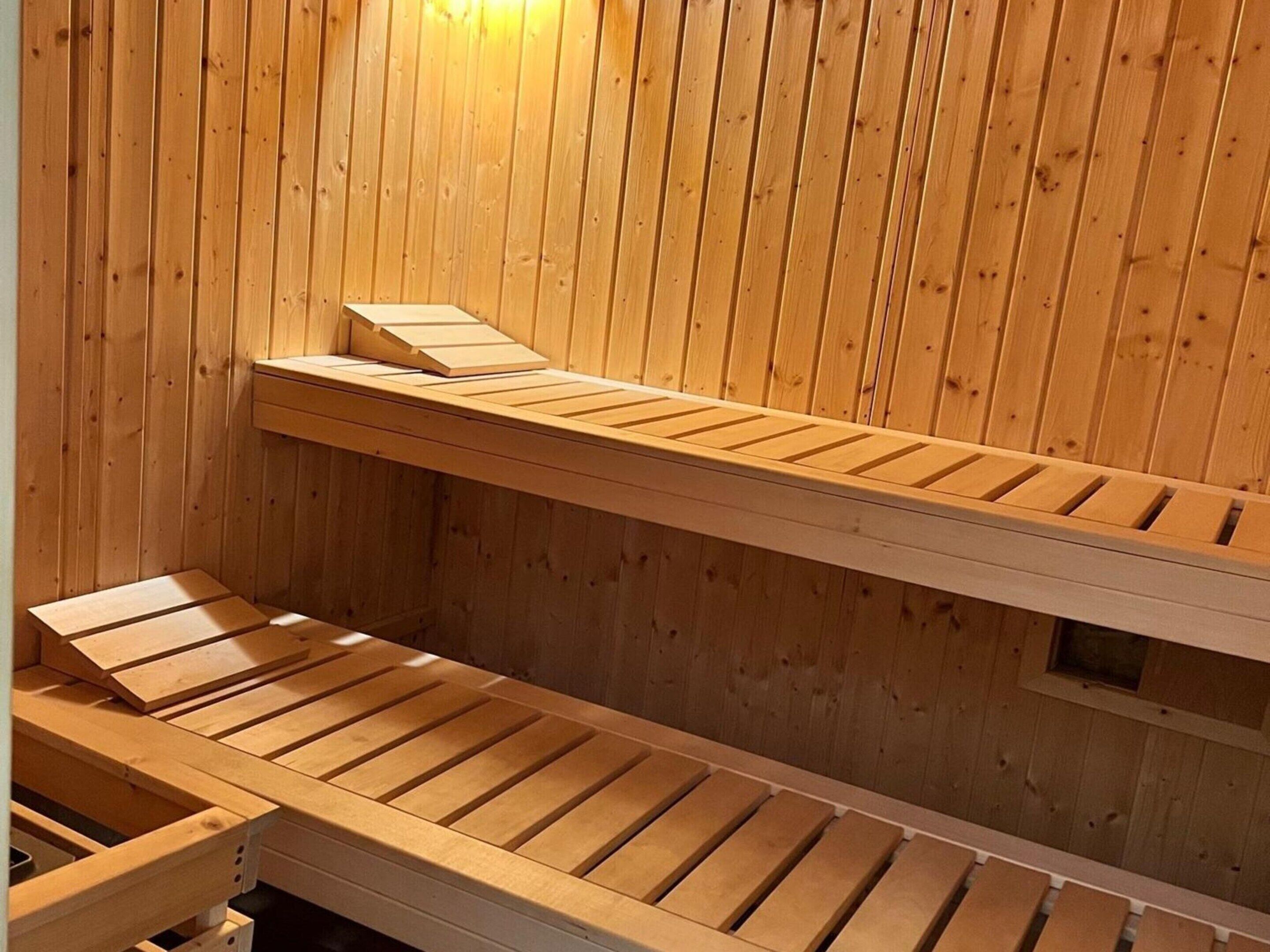 En sauna med træbænke og skrå vægge.