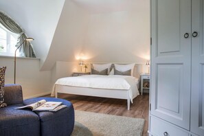 A bedroom with a bed, bedside tables, a lamp, a wardrobe, and a window with curtains. - Ferienhaus, Fuhlendorf (Fuhlendorf)