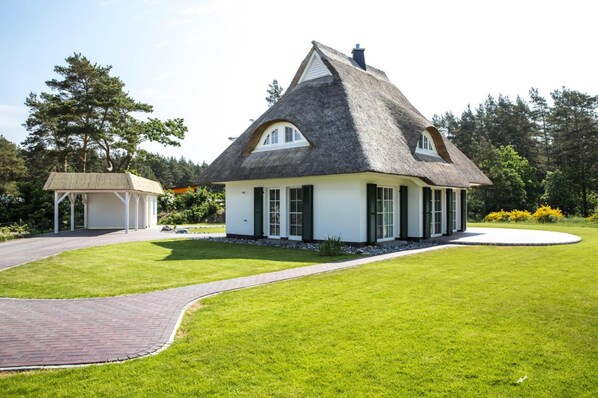 A house with a thatched roof, white exterior walls, and a small porch. - Ferienhaus, Fuhlendorf (Fuhlendorf)