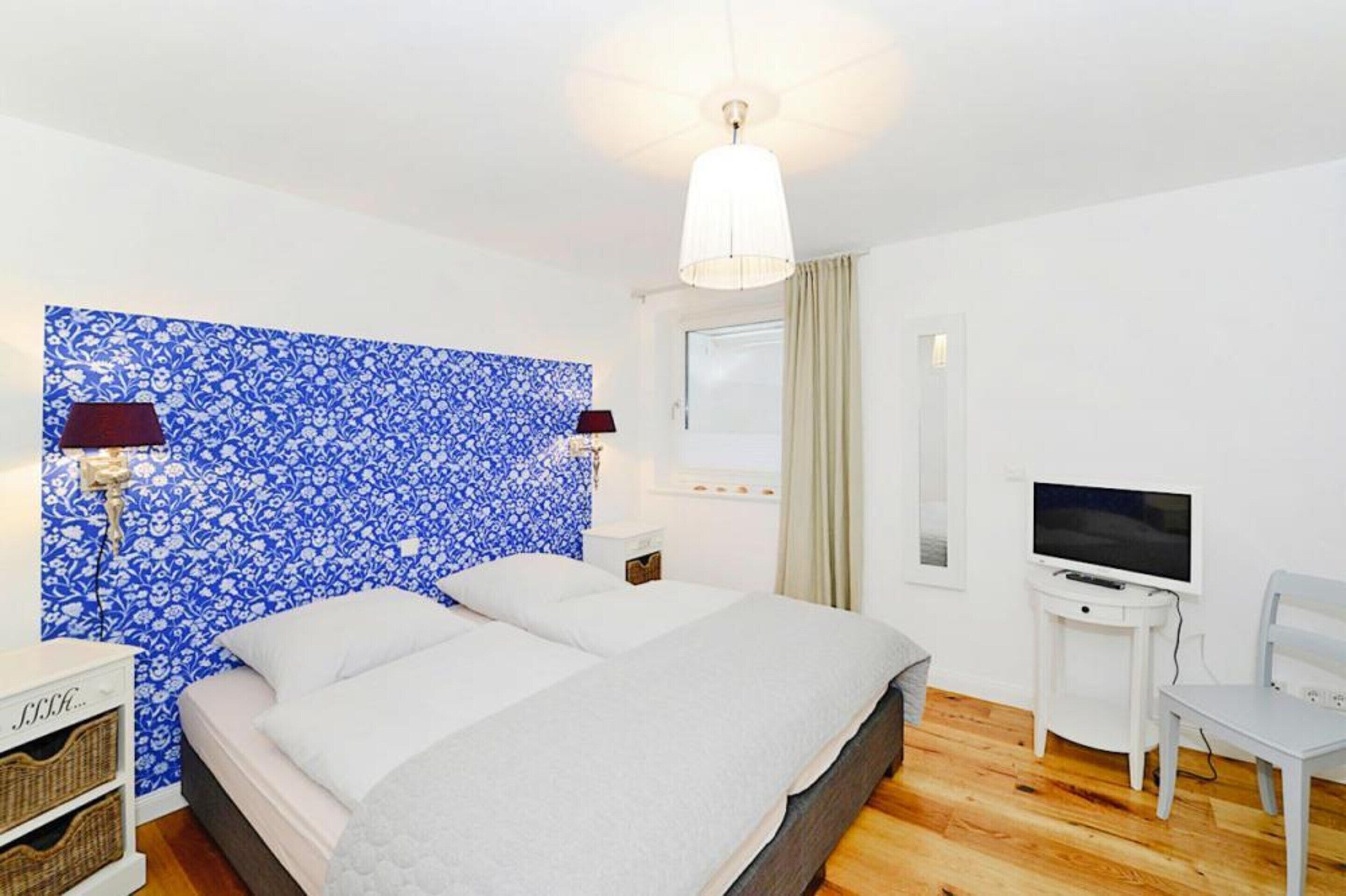 Ein Schlafzimmer mit einem großen Bett, einem Fernseher und einem Schreibtisch.