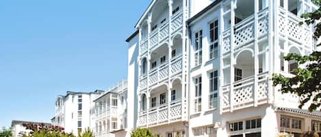 A white building with multiple balconies and large windows.