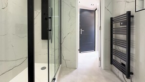 A modern bathroom with a glass shower enclosure, a black towel rack, and a marble floor. - Luxueux Haut de Villa 4 Pers à 30m de la Plage (Sainte-Maxime)