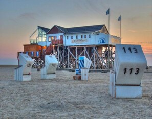 A beachside building with a sign reading "Peter-Ordeus" and "Die Sekretiste". - Ferienwohnung, St. Peter-ording (St. Peter-Ording)