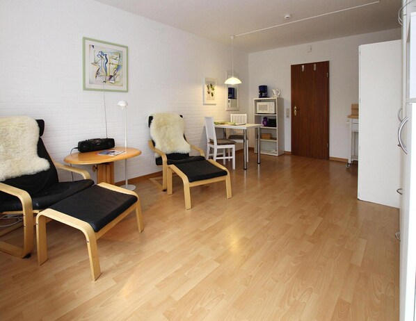 A room with two chairs, a small table, a whiteboard, and a door. - Ferienwohnung in Westerland auf Sylt (Sylt)