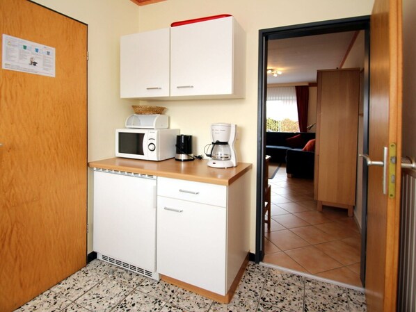 A compact kitchenette with a microwave, coffee maker, and a small refrigerator. - Reihenhaus, Dornumersiel (Dornum)