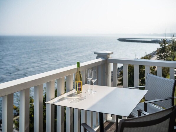 A balcony with a table and chairs overlooking the sea. - Beech Resort Boltenhagen (Boltenhagen)