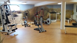A gym with various exercise equipment, including a treadmill, stationary bike, and weight machine. - Appartementhaus Jann-berghaus, Norderney (Norderney)