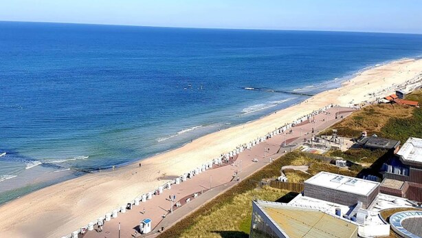 A coastal view with a beach, promenade, and buildings. - Ferienwohnung in Westerland auf Sylt (Sylt)
