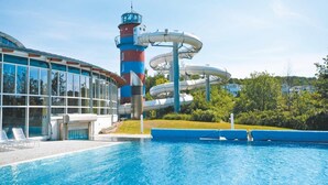 En swimmingpool med et vandrutsjebane-anlæg og et højt tårn.