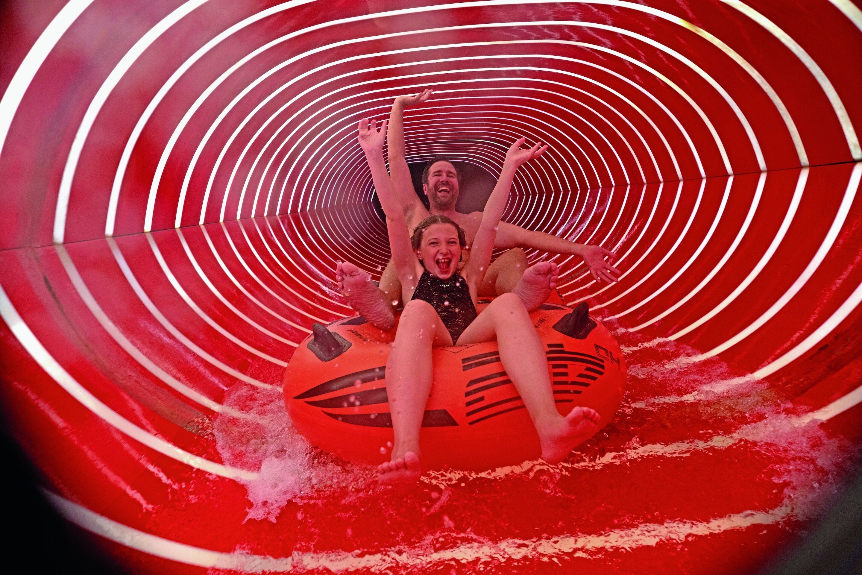 Eine Wasserrutsche mit einem rot-weiß gestreiften Tunnel.