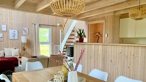 Un intérieur en bois comprenant une table à manger, des chaises, un canapé et un escalier.