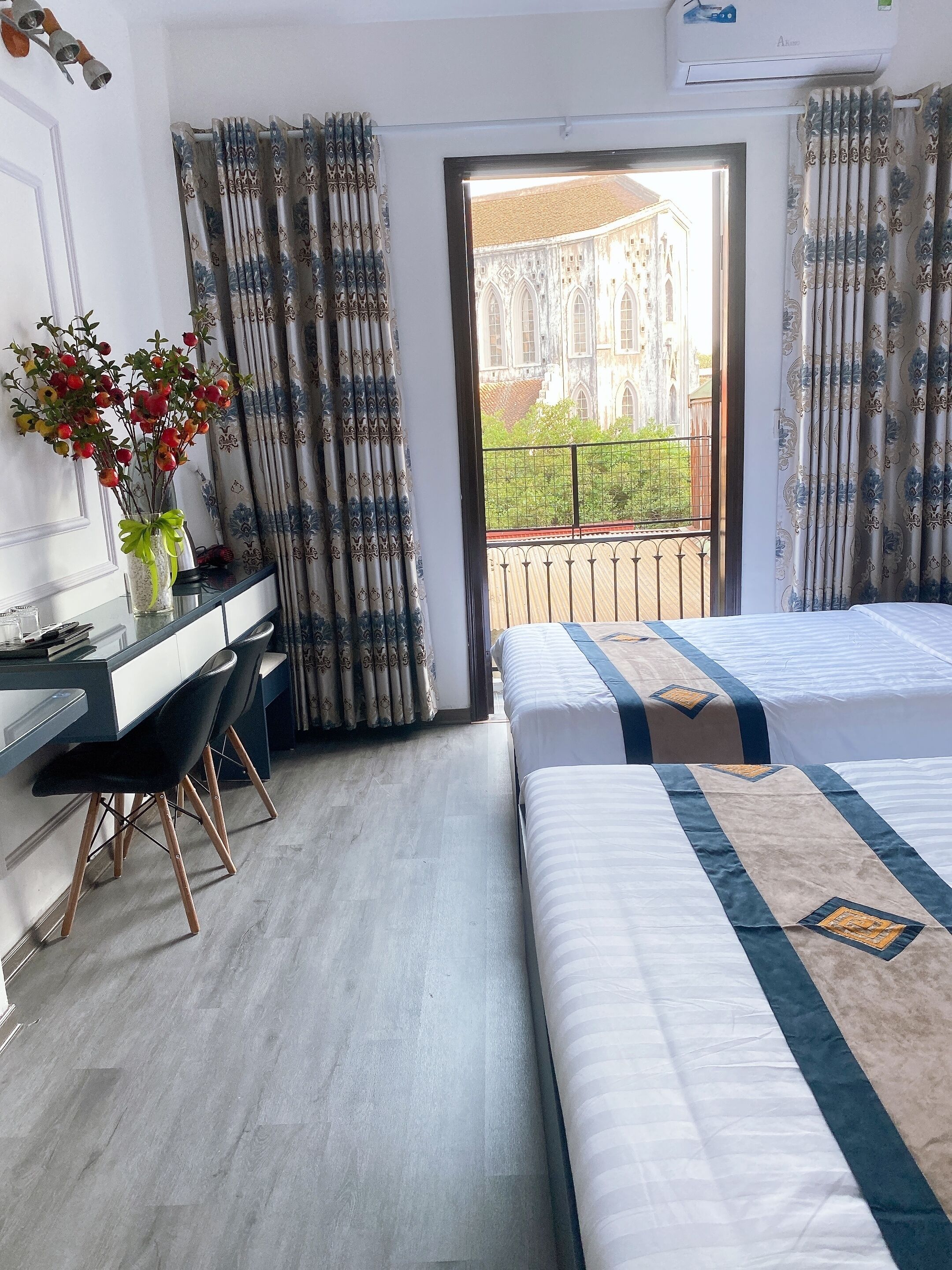Una habitación de hotel con cama, escritorio y vista a un edificio desde la ventana.