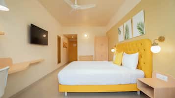 A modern bedroom with a large bed, a ceiling fan, a flat-screen TV, and a wooden nightstand.