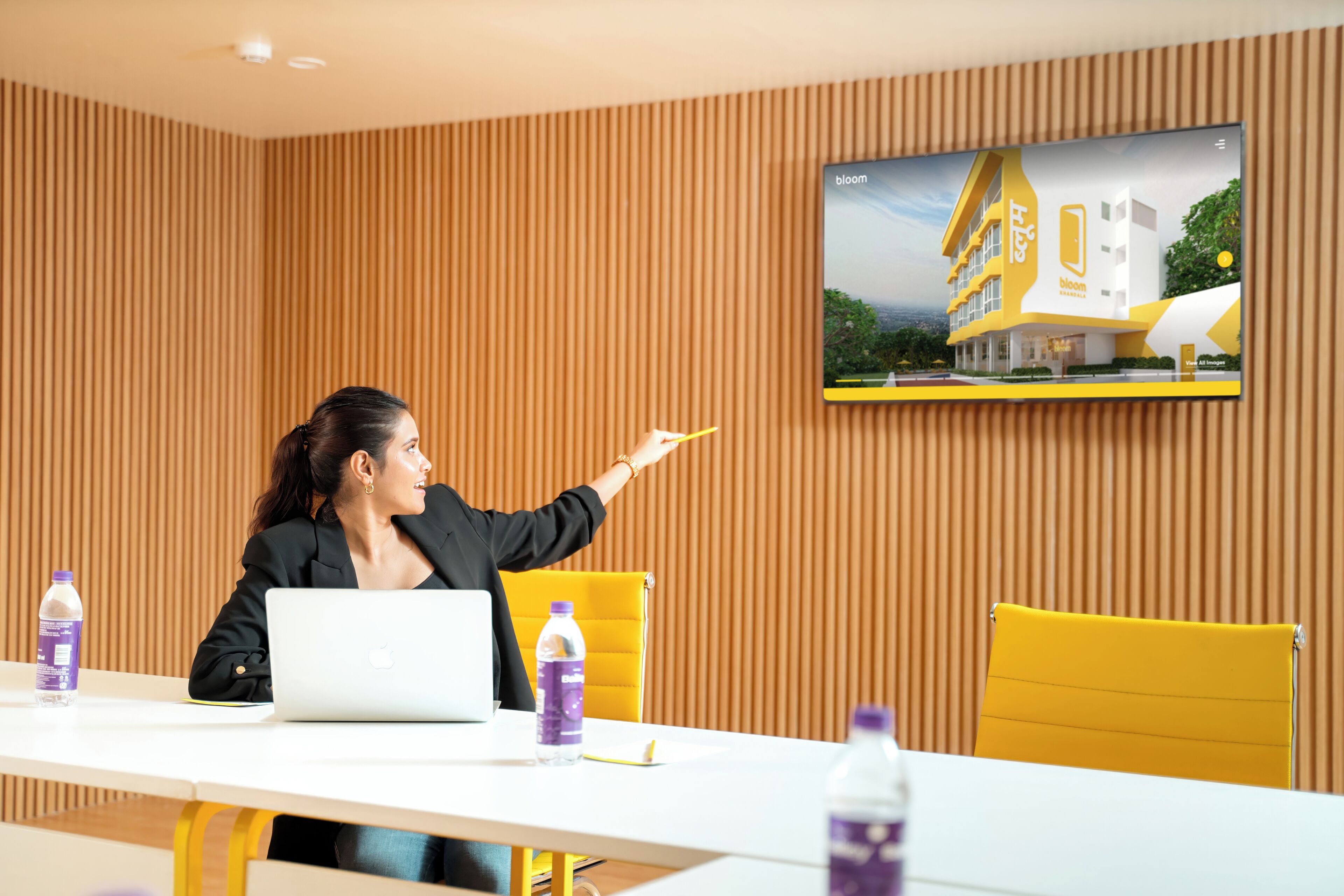 A person pointing at a screen displaying a building.