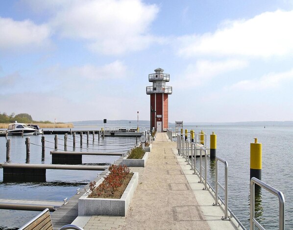 A lighthouse at the end of a pier with a clear sky. - Ferienwohnung in Plau am See (Plau am See)