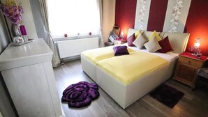 A bedroom with a bed, bedside tables, a dresser, a window, and a potted plant. - Holiday Home in Storkow Near Storkow Castle (Storkow)