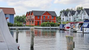 A waterfront property with a red house, a blue house, and a white house. - Ferienwohnung in Plau am See (Plau am See)